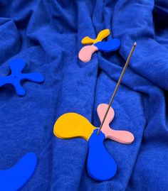 some blue and yellow items are laying on a blanket with a stick in the middle