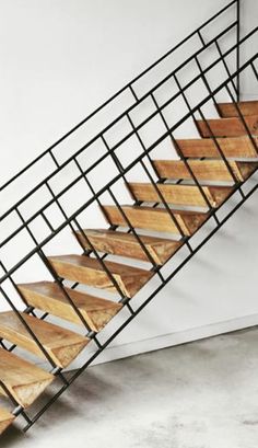 a metal and wood staircase in an empty room