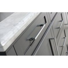 an image of a marble counter top with drawers and pulls on the bottom part of it