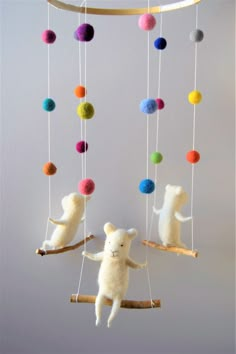 two stuffed animals are hanging from a mobile