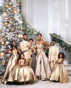 a group of people standing in front of a christmas tree