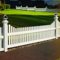 a white picket fence in front of a large house