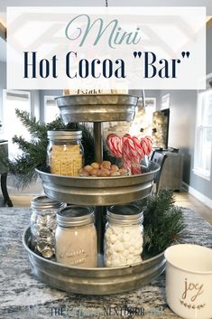 a three tiered tray filled with hot cocoa and marshmallows on top of a kitchen counter