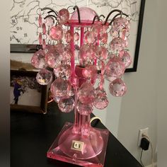 a pink lamp with lots of glass beads on it