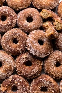 a pile of sugared donuts sitting on top of a white table next to each other