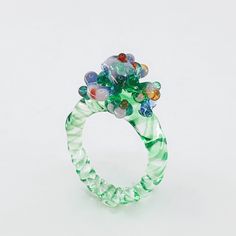 a green ring with multicolored glass beads on it's center and sides