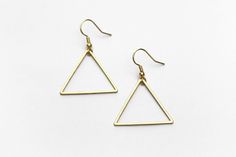 "Lightweight, geometric triangle earrings perfect for your next day out in the summer sunshine. ▲ Brass triangles measure approx. 1 1/4\" ▲ Gold-plated surgical steel earring hooks (hypoallergenic) We try to display product colors as close to life as possible. However, all monitors are different and so there might be slight color variations from screen to screen. CARE INSTRUCTIONS Jewelry should be kept away from moisture as much as possible. Remember to take your jewelry off before swimming and Minimalist Earrings For Summer, Adjustable Geometric Minimalist Earrings, Adjustable Minimalist Geometric Earrings, Minimalist Adjustable Earrings For Summer, Adjustable Minimalist Earrings For Summer, Trendy Triangle Earrings, Minimalist Summer Earrings, Minimalist Summer Earrings With Ear Wire, Minimalist Triangle Nickel-free Earrings