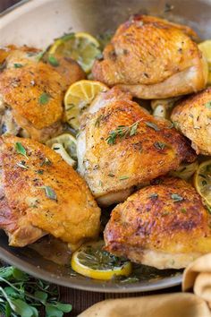 chicken with lemons and herbs in a pan