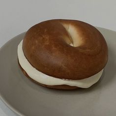 a bagel on a plate with icing and white frosting in the middle