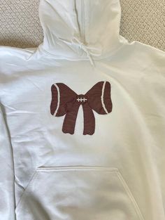 a white hoodie with a brown bow on it