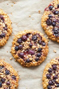 four blueberry breakfast cookies on top of parchment paper with the words, flourless blueberry