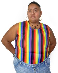 a woman with her hands on her hips wearing jeans and a tank top that has multi - colored stripes