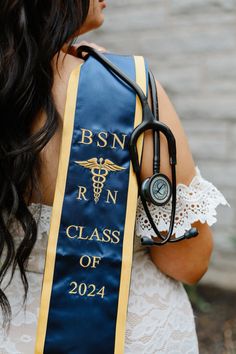 a woman wearing a blue graduation sash with a stethoscope on it