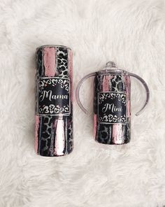 two pink and black canisters sitting on top of a white fur covered floor