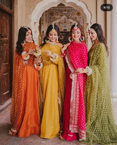 three women in colorful dresses standing next to each other