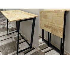 two wooden tables sitting next to each other on top of carpeted flooring in front of a wall