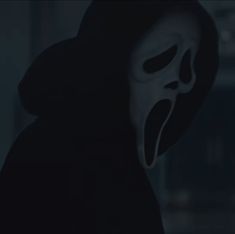 a person wearing a scary mask in the dark