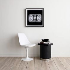 a white chair sitting next to a black table on top of a hard wood floor