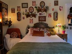 a bed sitting in a bedroom next to a wall with pictures on it's walls