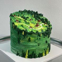 a green cake with trees and animals on it