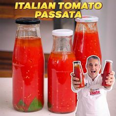 there is a man holding two bottles of tomato sauce and another bottle with something in it