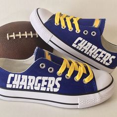 two shoes with chargers painted on them next to a football