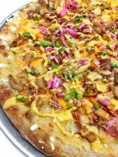 a pizza topped with lots of toppings sitting on top of a pan