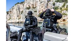 two people in scuba gear on a boat