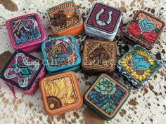 six small square tins with designs on them