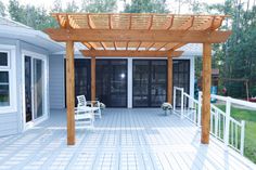 a wooden pergolan sitting on top of a white deck