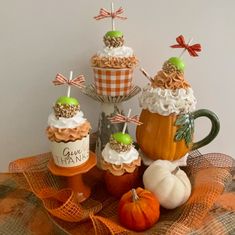 cupcakes and pumpkins are arranged on a table