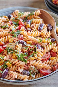 a pasta salad with tomatoes, olives and other vegetables