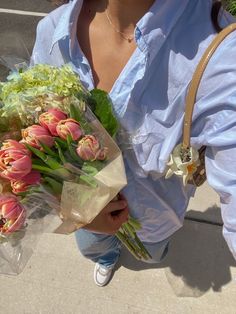 a woman is holding a bouquet of flowers