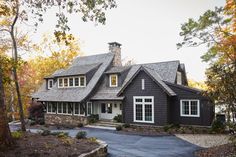 a large house in the woods with lots of trees around it and a driveway leading up to it