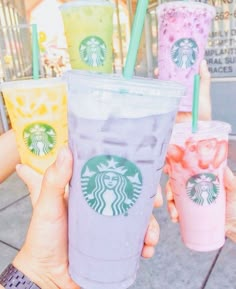 four different colored starbucks drinks with straws in their cups and one being filled with ice