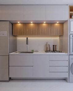 a kitchen with a refrigerator, sink and microwave in it's center island next to a washer and dryer