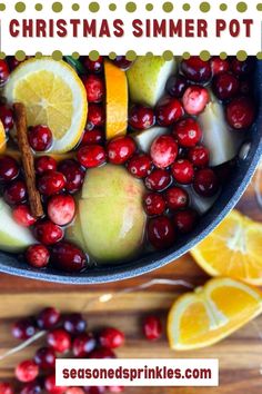 a pot filled with cranberries, apples and oranges next to some cinnamon sticks