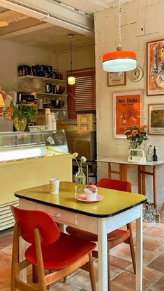 a table and chairs in a room with pictures on the wall