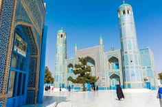 two women walking in front of an elaborately decorated building with blue and white tiles