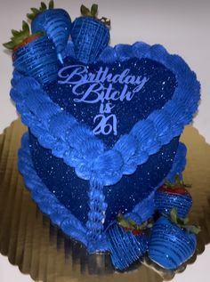 a blue heart shaped birthday cake with strawberries