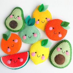 felt fruit ornaments are arranged on a white surface