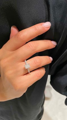 a woman's hand with a diamond ring on it