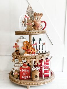 a three tiered tray with gingerbread cookies and christmas decorations