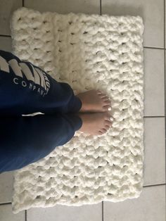 a person standing on top of a white rug with their feet in the middle of it