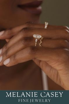 a close up of a person's hand with two rings on it and the words melanie casey fine jewelry