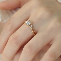 a woman's hand with a diamond ring on top of her finger and an engagement band