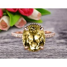 an oval cut yellow sapphire ring with pave diamonds on the band and rose petals in the background