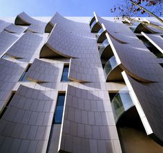 the facade of a building with many windows and curved roof tiles on it's sides