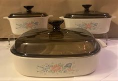 three white casserole dishes with brown lids