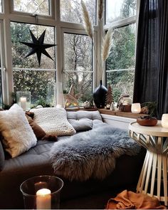 an instagram photo of a living room with lots of pillows and blankets on the couch